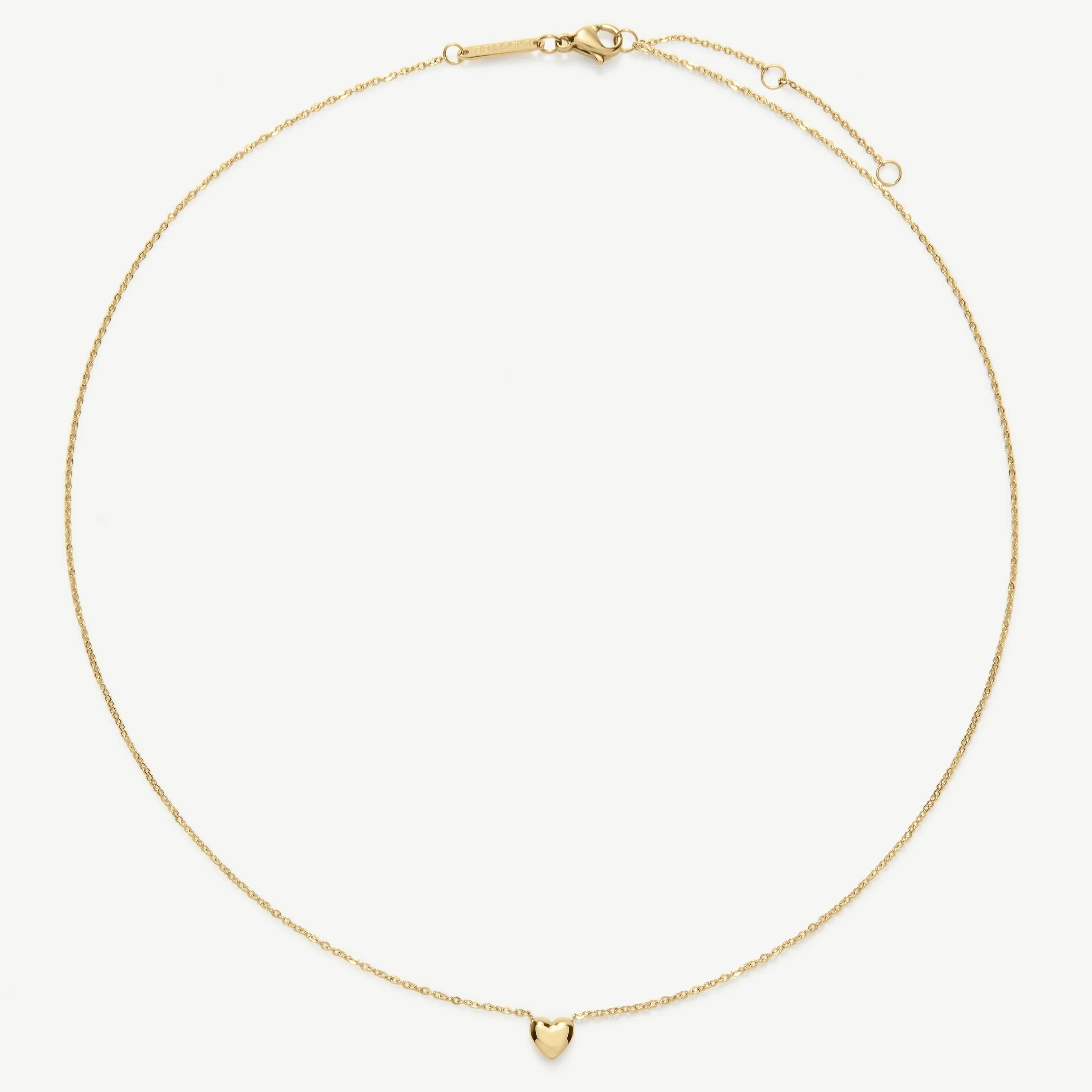 Delicate gold chain necklace with a small heart pendant on a white background