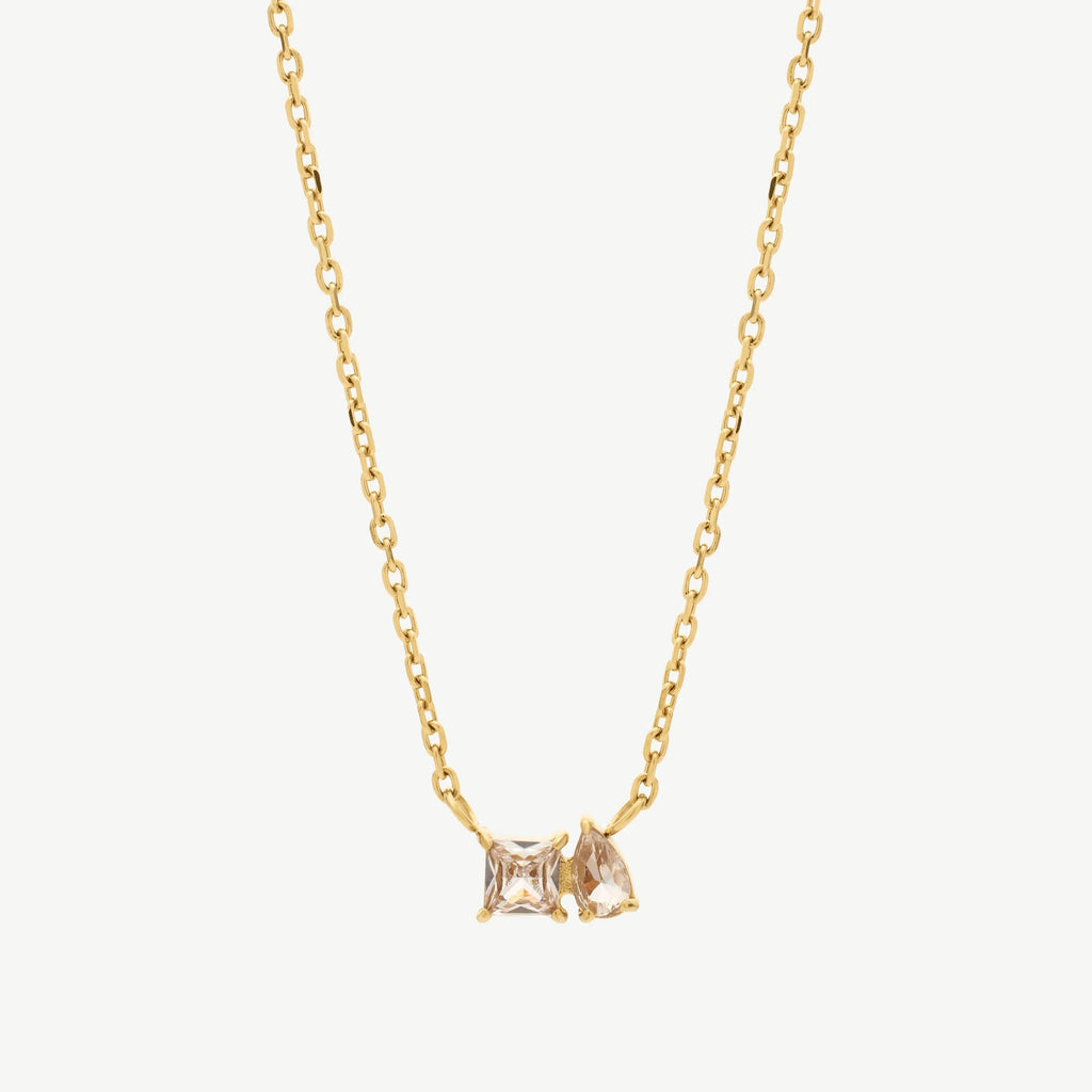 Gold chain necklace with square and pear-shaped clear crystal pendants on white background