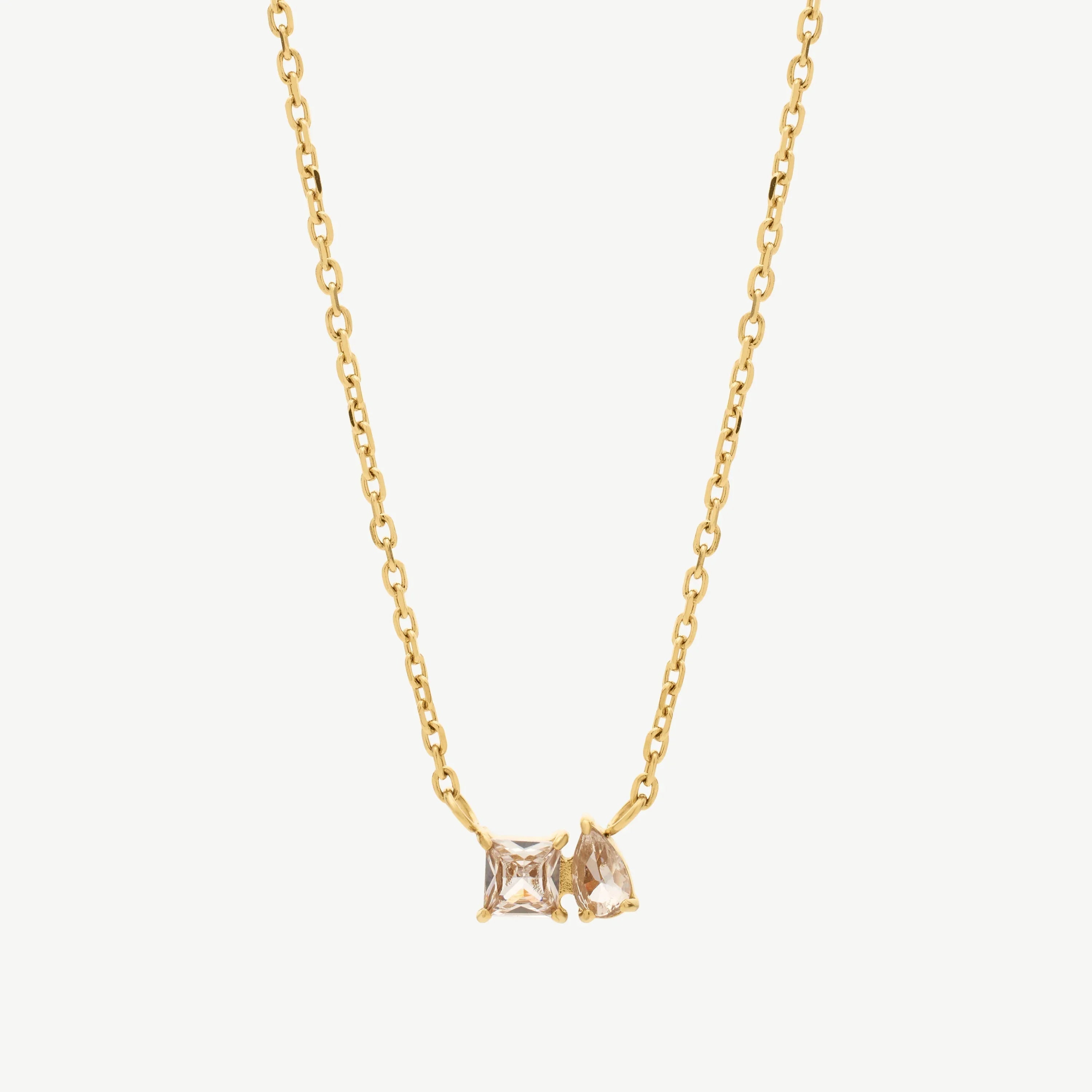 Gold chain necklace with square and pear-shaped clear crystal pendants on white background