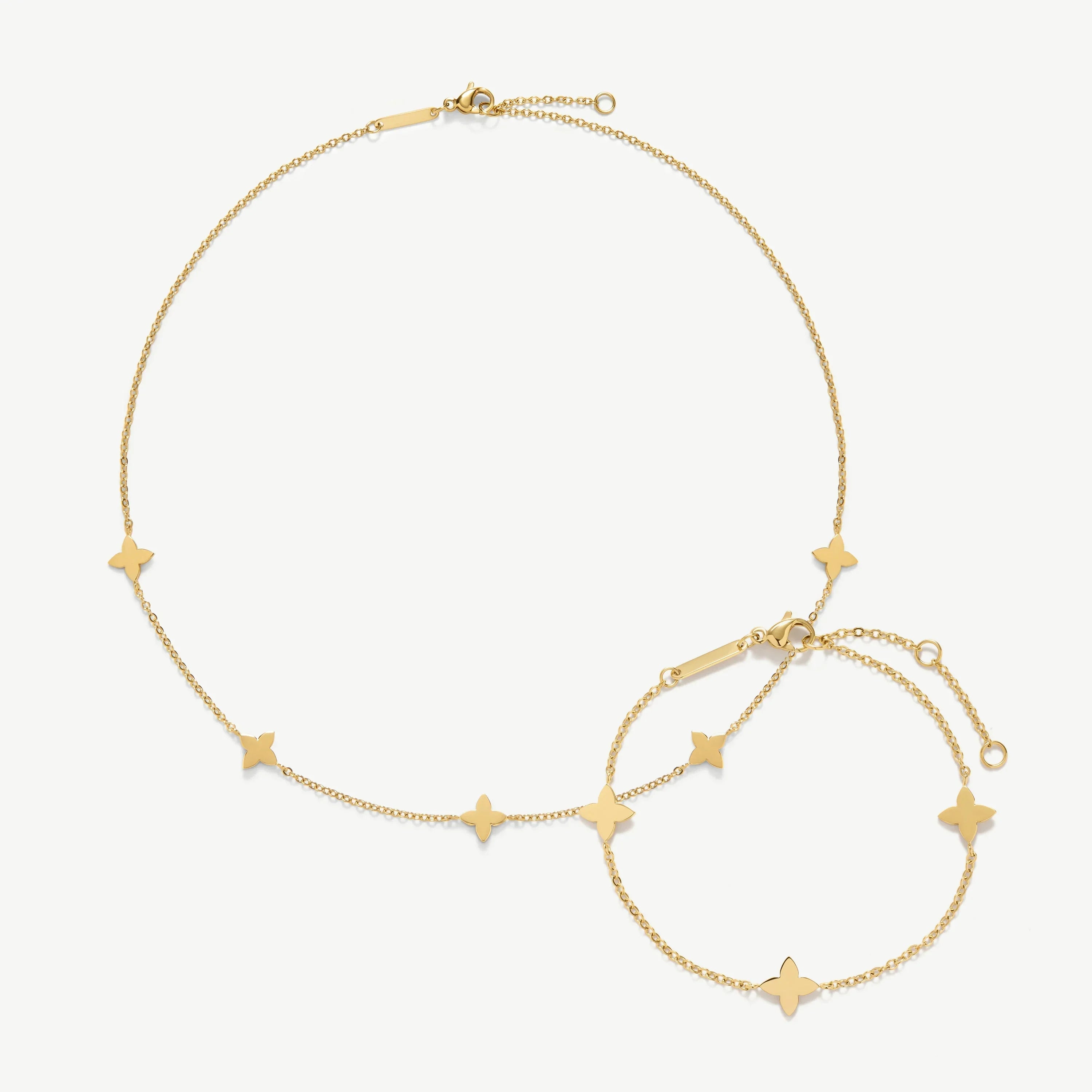 Delicate gold chain necklace and bracelet with small star-shaped charms on white background
