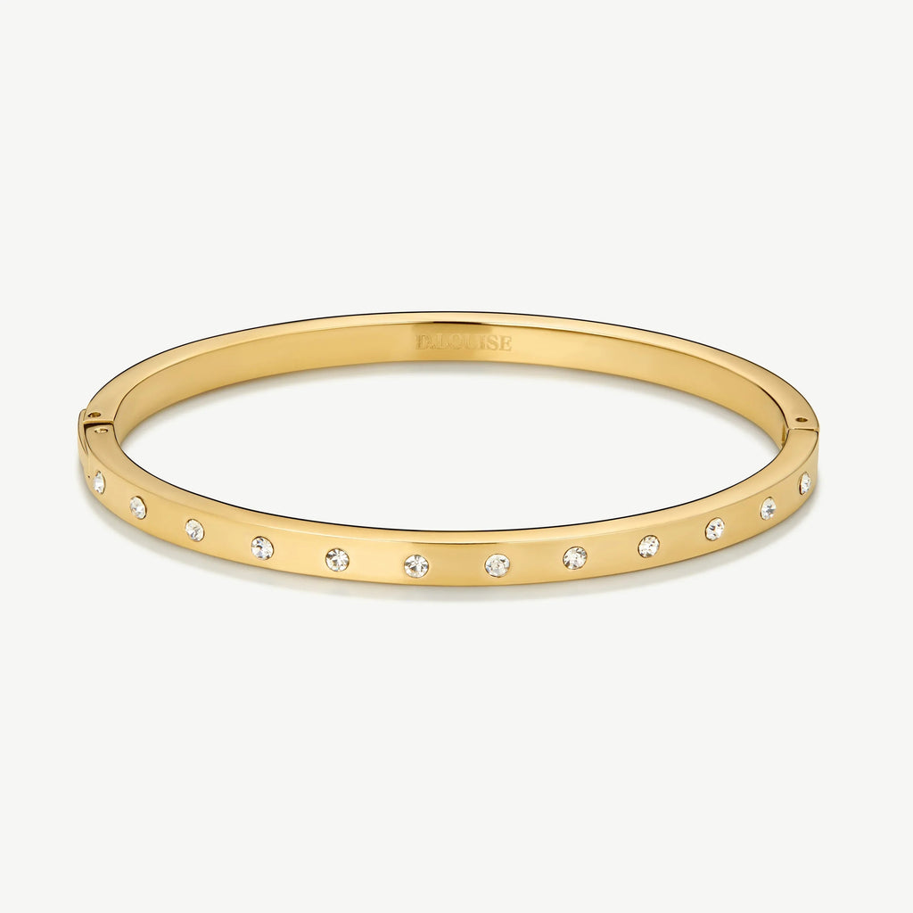 Gold bangle bracelet with evenly spaced small crystals on white background