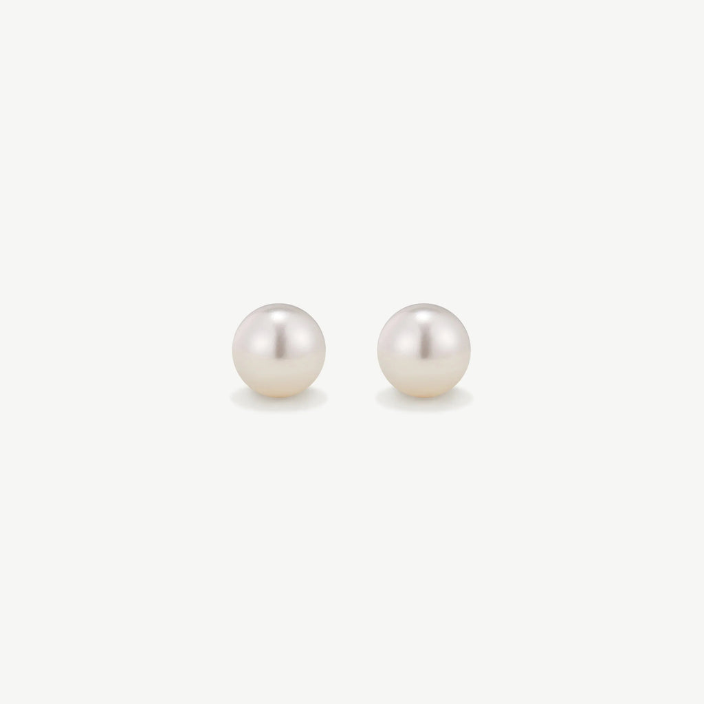 Pair of elegant white pearl stud earrings on a plain white background