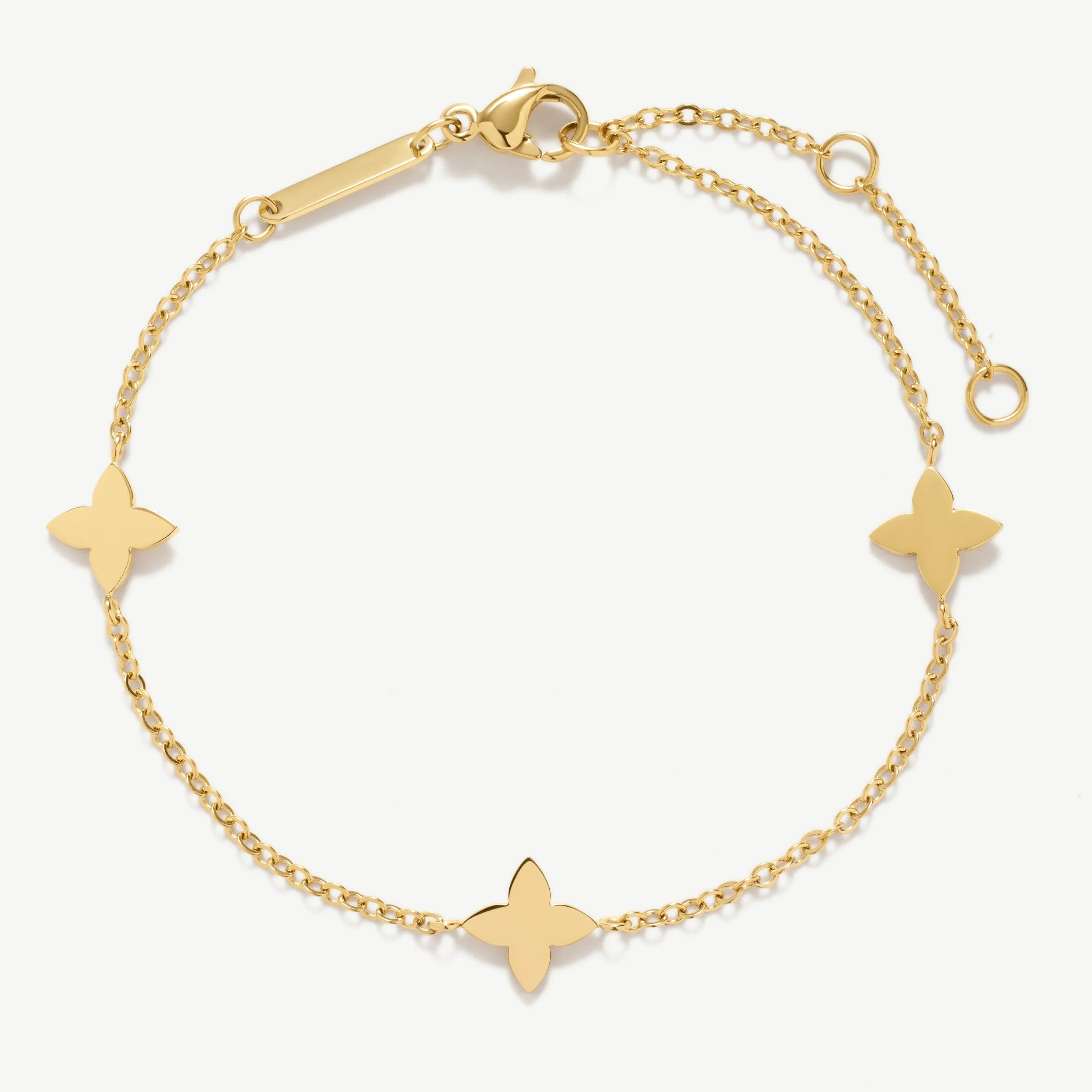 Gold chain bracelet with three flower-shaped charms and lobster clasp on white background