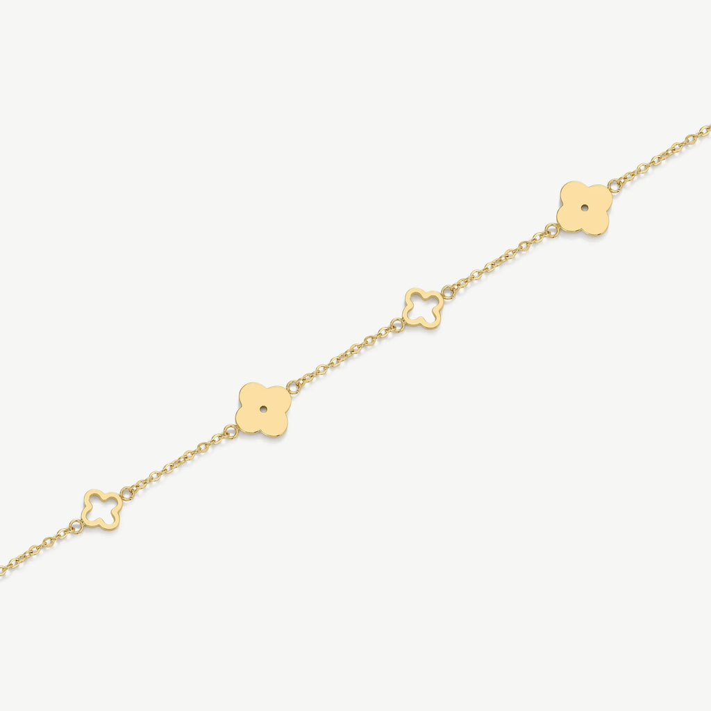 Delicate gold chain bracelet with alternating solid and hollow four-leaf clover charms on white background
