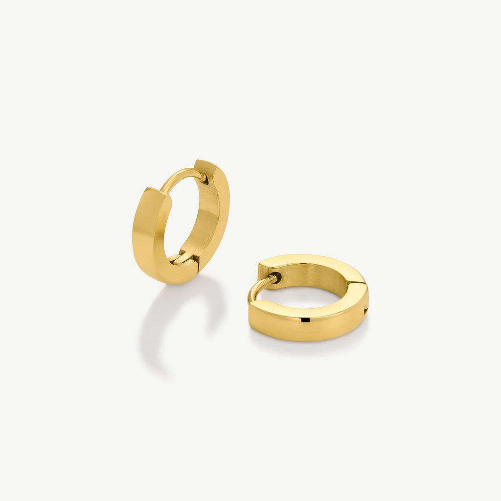 Pair of polished gold hoop earrings on white background with reflective shadows