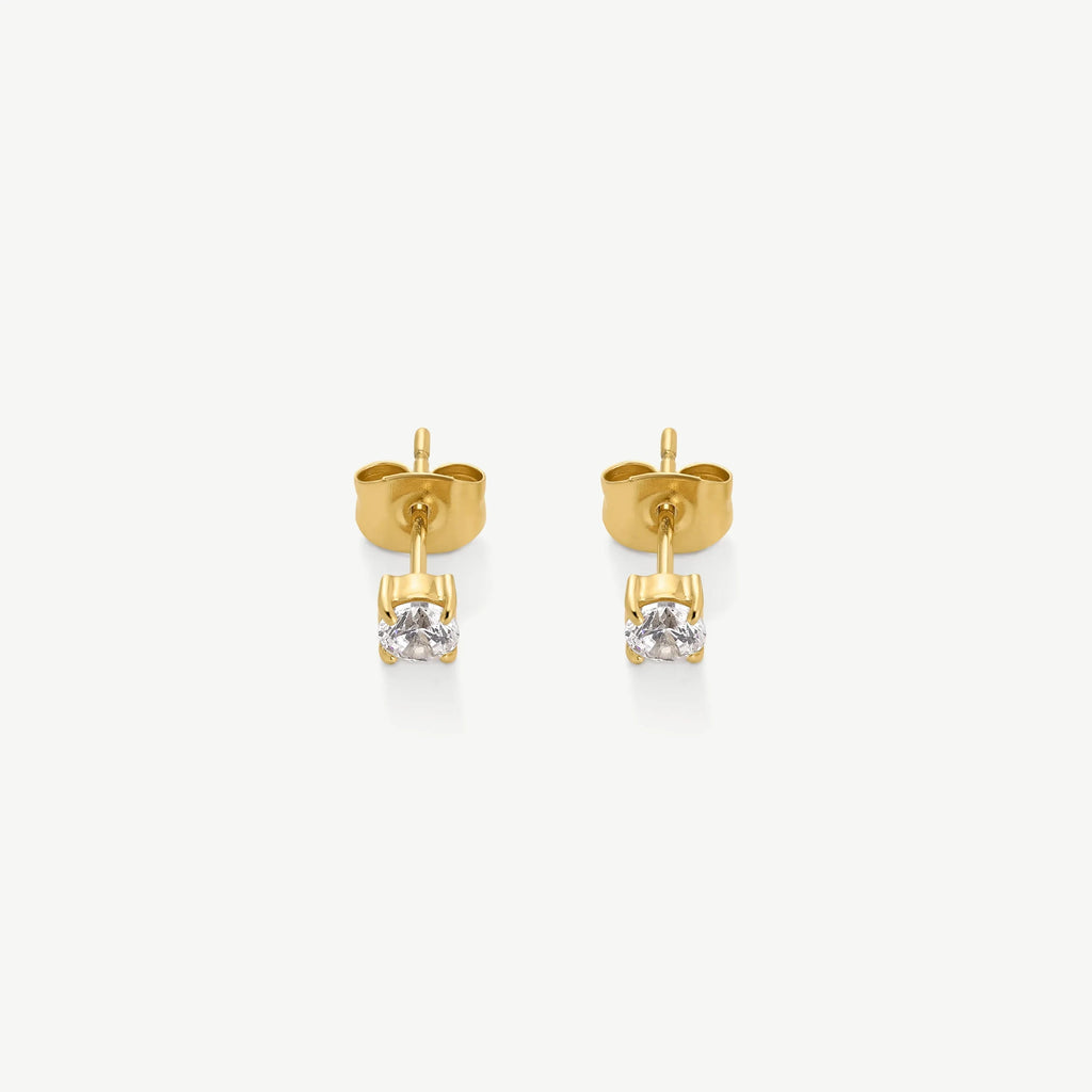 Pair of gold stud earrings with clear round-cut gemstones on white background