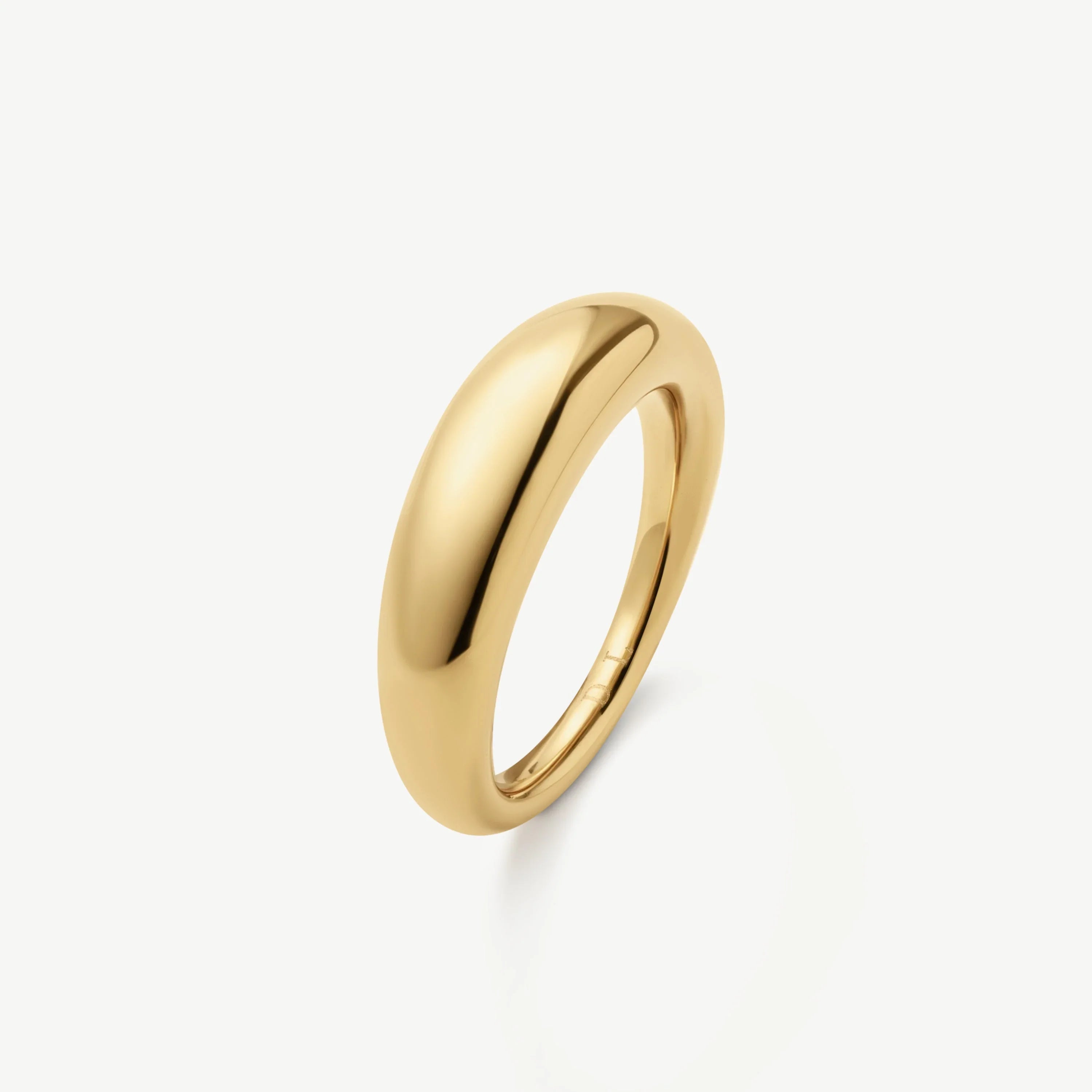 Simple polished gold dome ring on white background, smooth rounded band jewelry