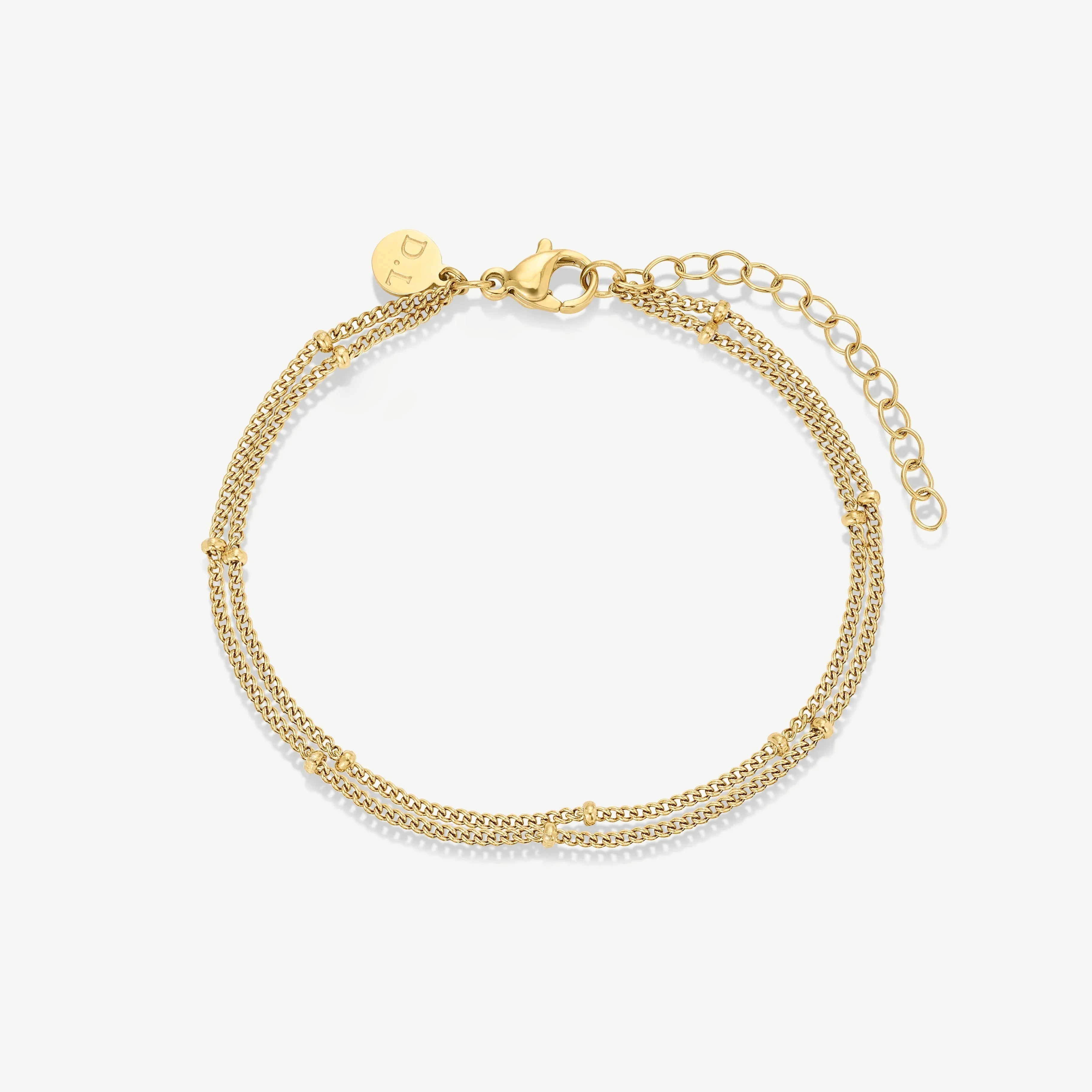 Delicate gold double chain bracelet with small beads and lobster clasp on white background
